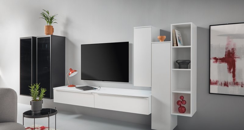 Bílá minimalistická závěsná komoda a panelový systém doplněný dvěma elegantními závěsnými skříňkami s tmavým sklem a vnitřním osvětlením.