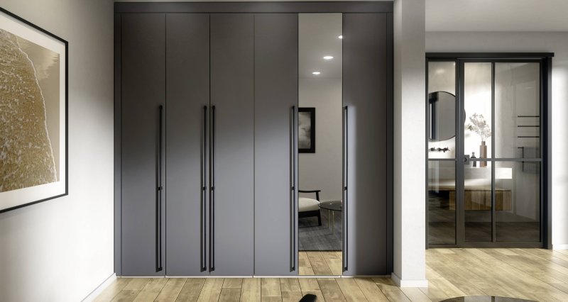 Tmavě šedá matná vestavná skříň na míru s úzkým vloženým zrcadlovým panelem a minimalistickými dlouhými černými úchytkami pro elegantní vzhled.