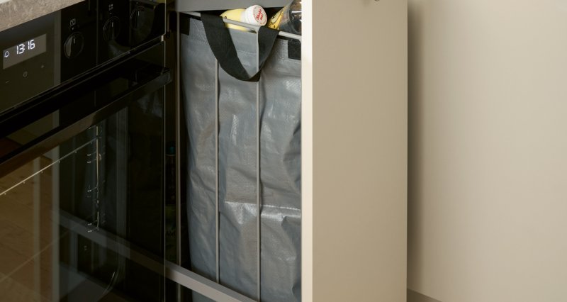 Otevřený hluboký výsuv ve spodní skříňce kuchyňské linky, který je vybaven pevnou vyjímatelnou taškou a boxem na tříděný odpad