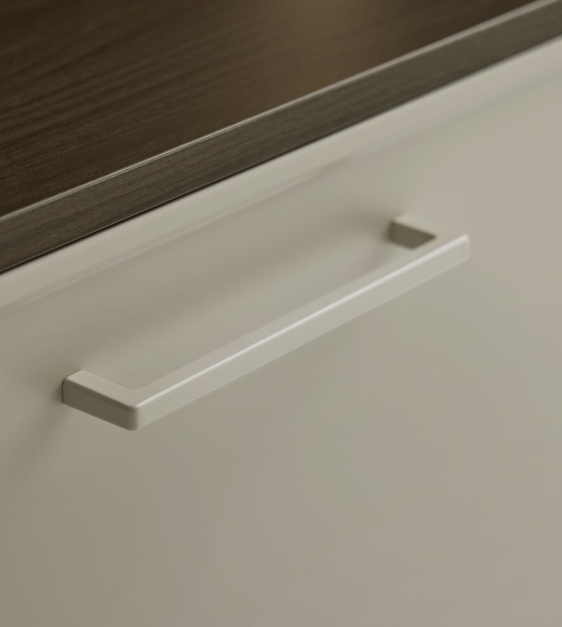 Detailní pohled na mimořádně úzký rámeček kuchyně Nolte Evora a minimalistickou úchytku v odstínu Greige.