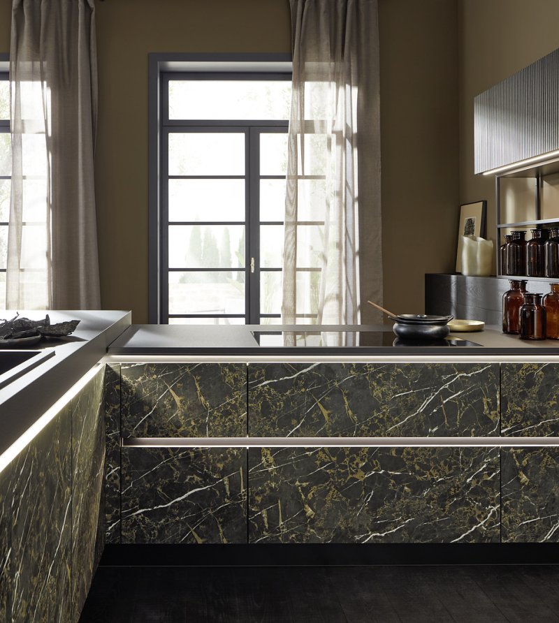 Detail rozhraní dřezové a varné zóny na ostrůvku v provedení neo MARBLE s černou pracovní deskou a zadní stěnou neo LODGE.