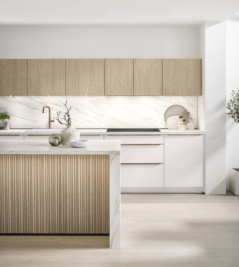 Detailní pohled na moderní kuchyňský ostrůvek Nobilia Softline 509 s vertikálními dřevěnými lamelami a pracovní deskou v imitaci mramoru Carrara Bronze.