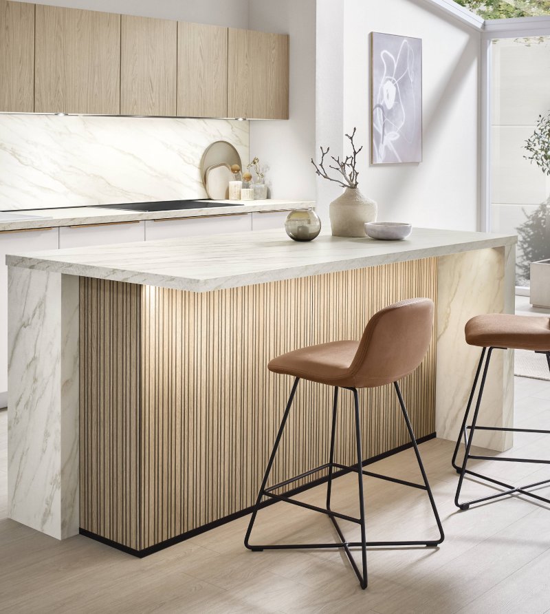 Detail integrovaného spodního osvětlení na lamelovém ostrůvku kuchyně Nobilia Softline 509 s mramorovou deskou Carrara Bronze.