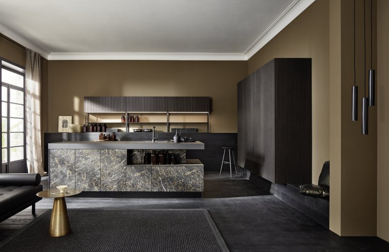 Široký záběr na luxusní kuchyni Nolte neo s mramorovým ostrůvkem, závěsnými skříněmi z černěného dubu a elegantním osvětlením.