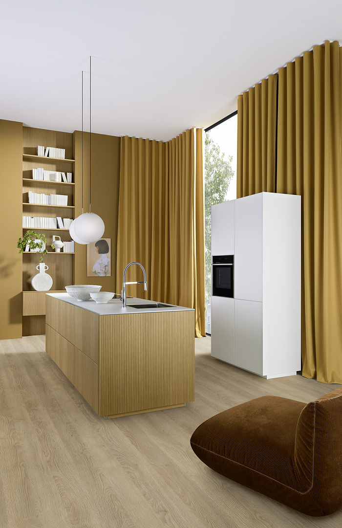 Kuchyňský ostrůvek Nolte neo LODGE s nerezovou baterií, skleněnou pracovní deskou Glas Tec Satin a bílými vysokými skříněmi se zabudovanou troubou.