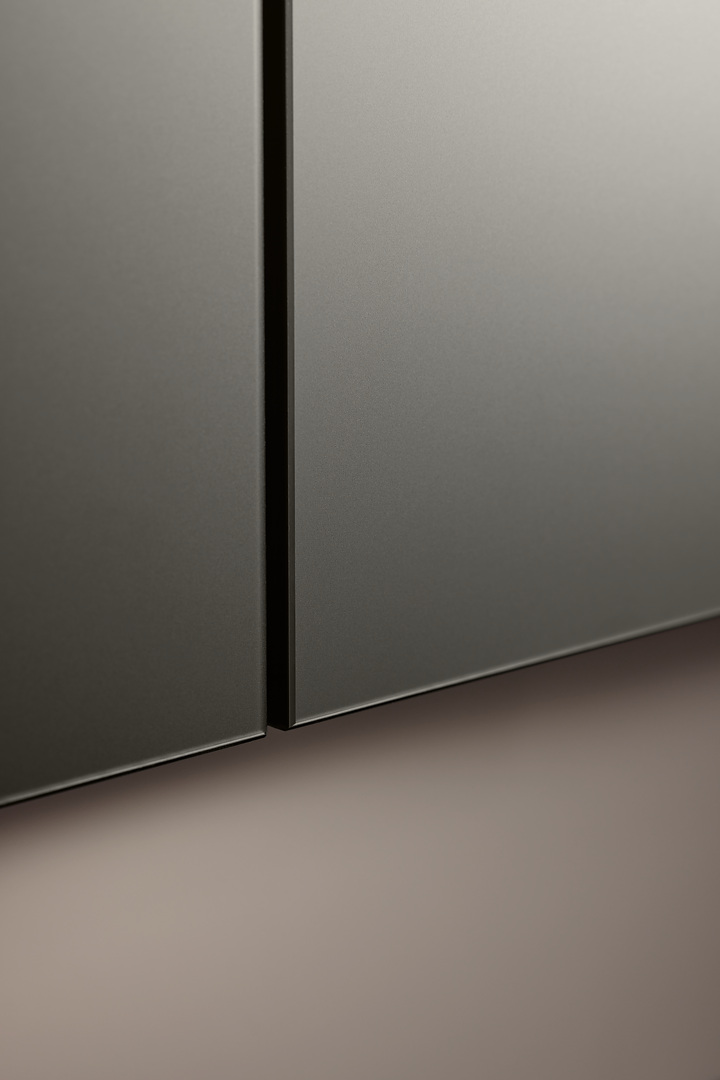 Detailní makro pohled na dokonalé zpracování hran a jemnou metalickou strukturu povrchu dvířek kuchyně Nolte Pearl Umbra.